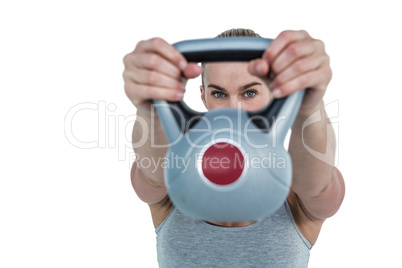 Serious muscular woman lifting kettlebell