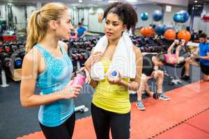 Fit women chatting in weights room
