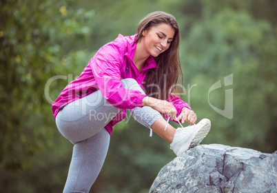 Fit woman tying her shoelace Fit woman tying her shoelace
