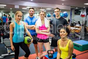 Fit people smiling at camera in weights room