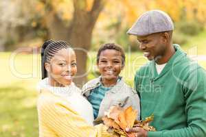 Portrait of a young smiling family holding leaves