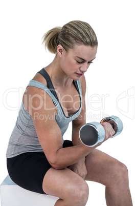 Muscular woman working out with dumbbells