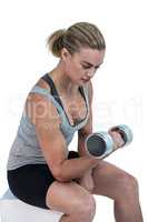 Muscular woman working out with dumbbells