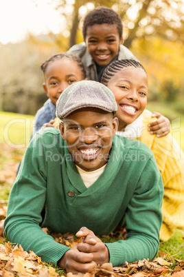 Portrait of a young smiling family lying in leaves