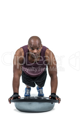 Fit man exercising with bosu ball