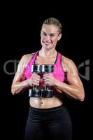 Muscular woman lifting heavy dumbbells