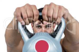 Muscular man lifting heavy kettlebell