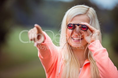 Happy blonde looking through binoculars