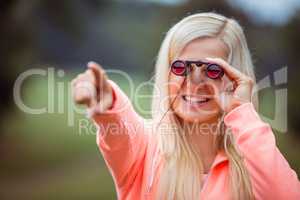 Happy blonde looking through binoculars