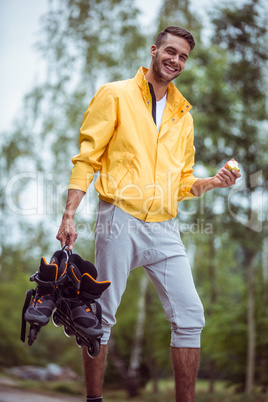 Handsome man holding inline skates