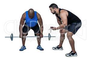 Man lifting barbell with trainer
