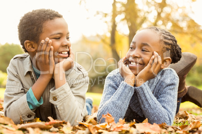 Portrait of young children lying in leaves