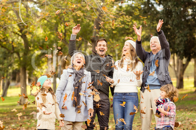 Happy extended family throwing leaves around
