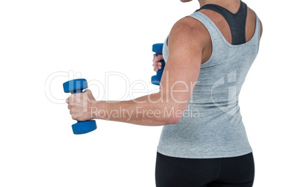 Muscular woman working out with dumbbells