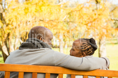 Happy senior couple discussing together on a bench