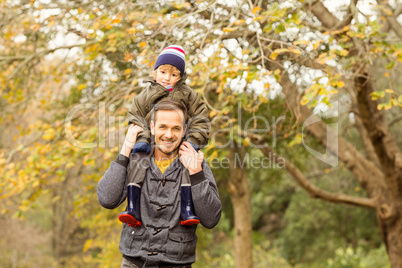 Young dad lifting his little son in park