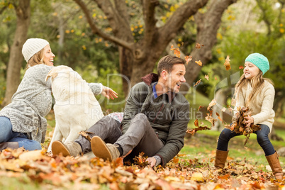 Young family with a dog in leaves