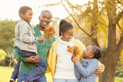 Portrait of a young smiling family holding leaves