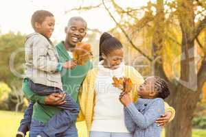 Portrait of a young smiling family holding leaves