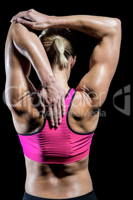 Muscular woman stretching her arms