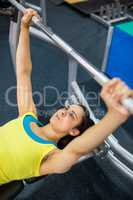 Determined woman lifting a barbell