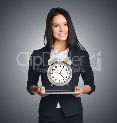 Business woman showing a metal alarm clock in front of him