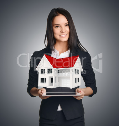 Business woman showing house symbolizing sale of real estate