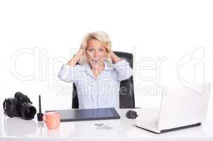 Frau mit Zeichentablett sitzt am Schreibtischt und kreischt