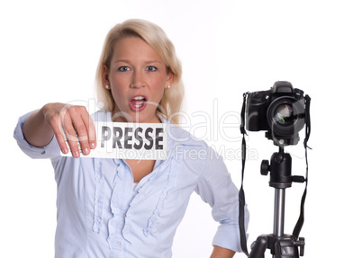 Energische Pressefotografin mit Kamera hält ein Presseschild