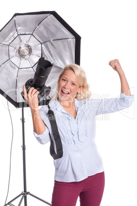 Frau mit Kamera im Fotostudio zeigt Begeisterung