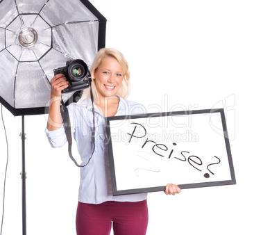 Fotografin hält eine Preistafel in der Hand und lächelt