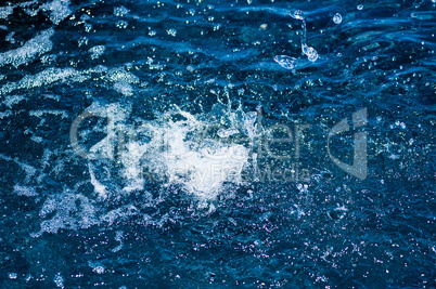 Splashing water and droplets on blue surface