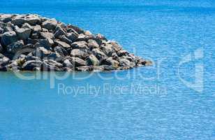 Edge of rocky breakwall ending in water