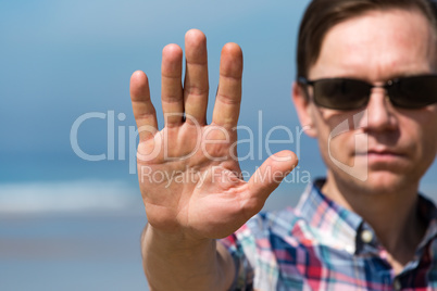 Man in Sunglasses Showing Stop Sign with his Hand