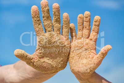 Woman and Man Shows his Open Hands Covered with Beach Sand