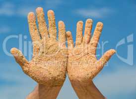 Woman and Man Shows his Open Hands Covered with Beach Sand