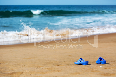 Women's Blue Slippers on a Sandy Ocean Beach