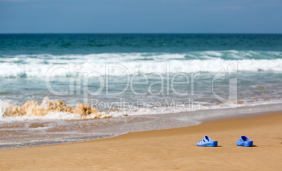 Women's Blue Slippers on a Sandy Ocean Beach