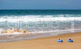 Women's Blue Slippers on a Sandy Ocean Beach