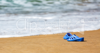 Women's Blue Slippers on a Sandy Ocean Beach