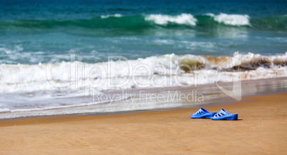 Women's Blue Slippers on a Sandy Ocean Beach