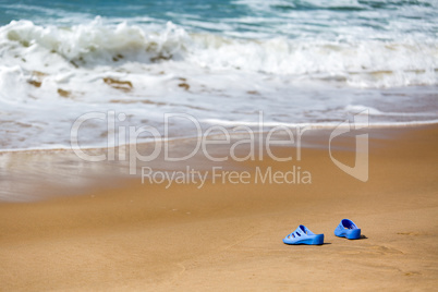 Women's Blue Slippers on a Sandy Ocean Beach