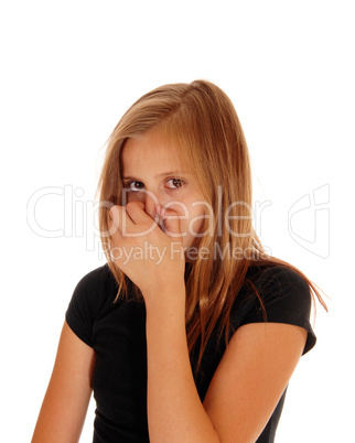 Young girl closing her nose with hand.