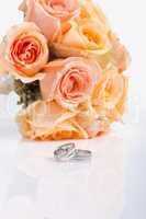 Silver wedding rings and a bridal bouquet