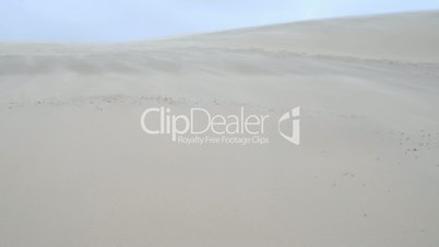 Sand blowing over a sand dune