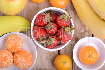 Fresh colorful fruits composition mandarin, strawberry, peach, bananas and orange