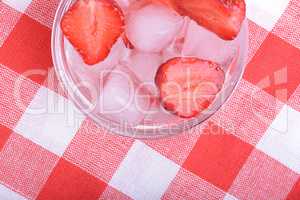 A slice of red strawberry on glass plate in party theme background
