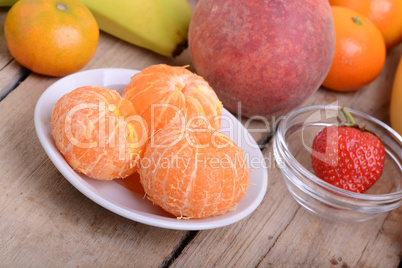 Fresh colorful fruits composition mandarin, strawberry, peach, bananas and orange