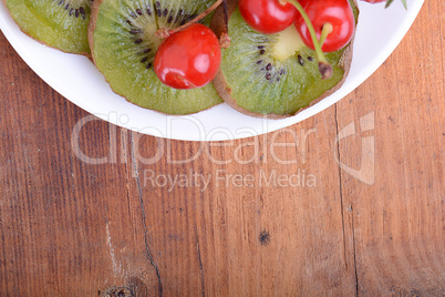 health fruit with cherry, kiwi slices on wooden plate