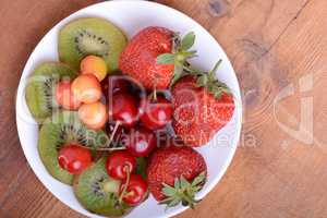 health fruit with cherry, strawberry, kiwi on wooden plate